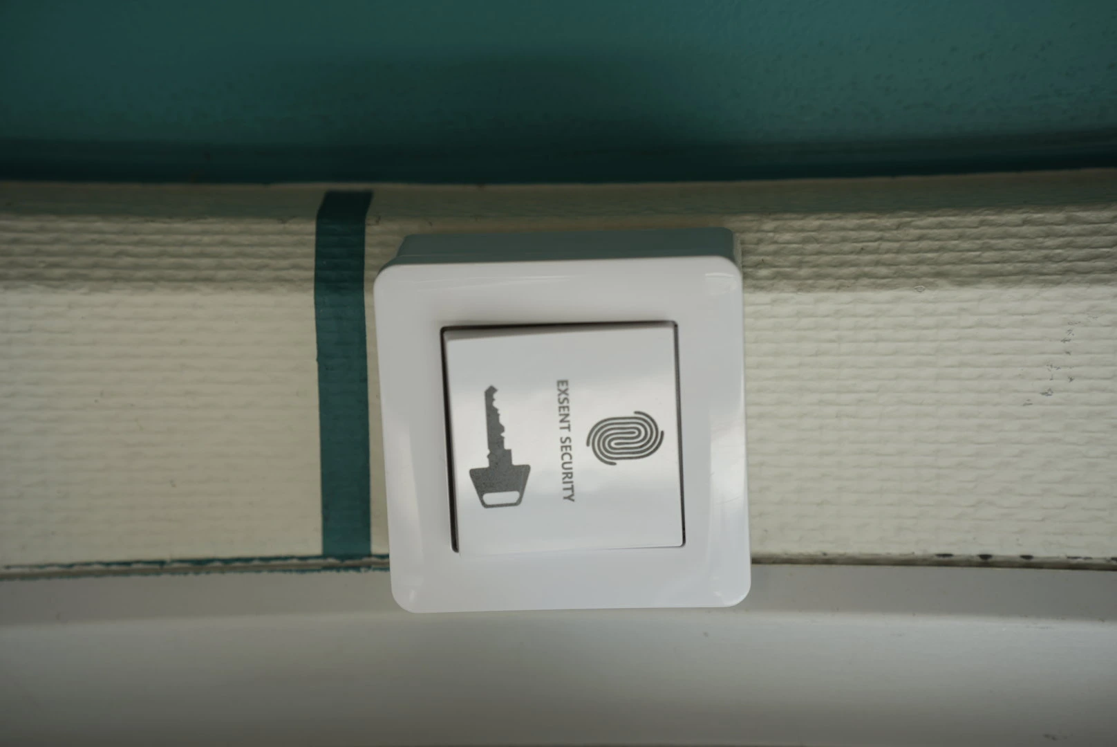 Modern kontorskorridor med säkerhetskamera, kodlås och kvinna i kostym.