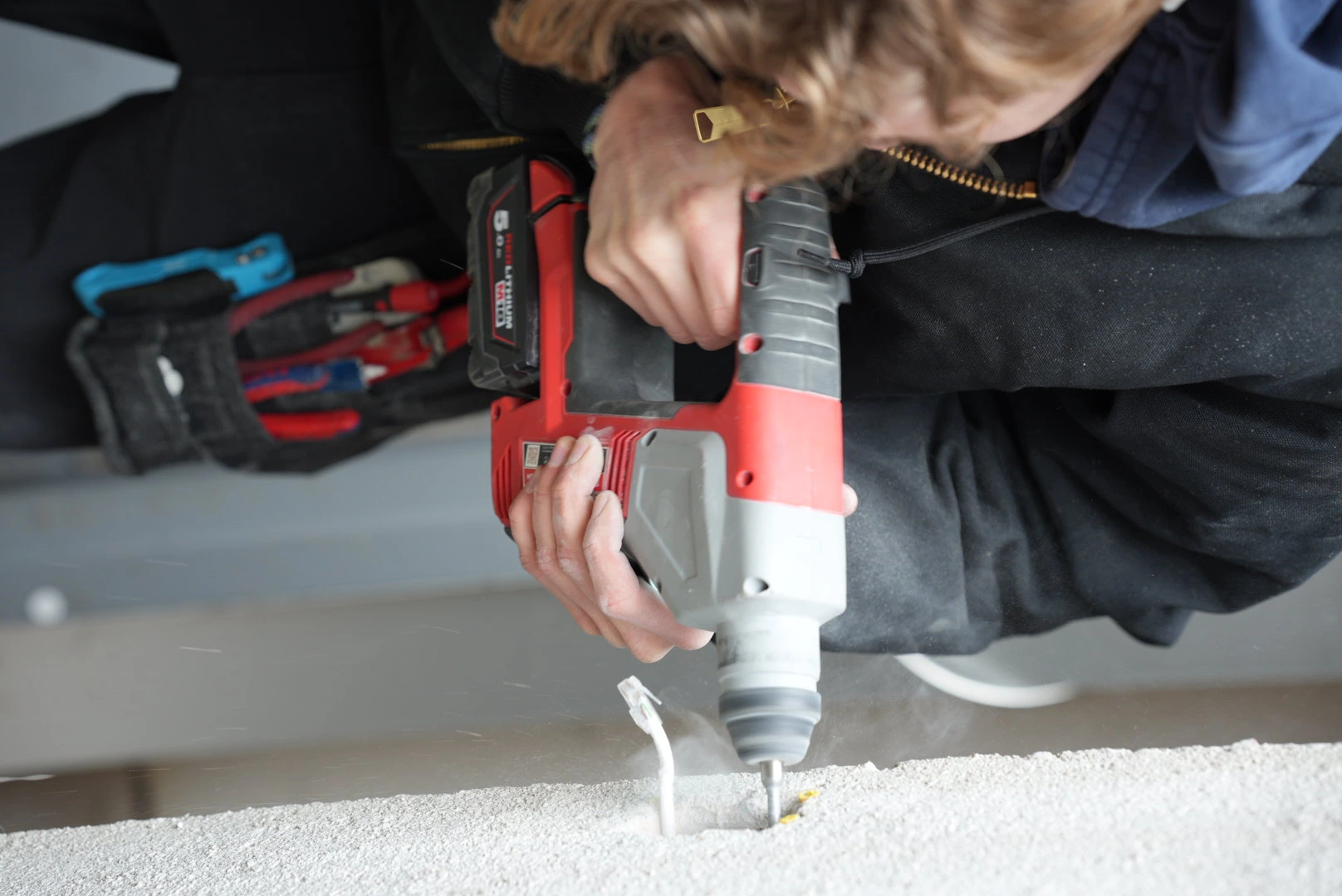 Övervakningskamera monterad på vägg med utsikt över stadsgata med fotgängare och trafik.