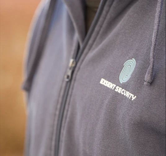 Säkerhetspersonal med surfplatta öppnar dörr i modernt kontorslandskap.