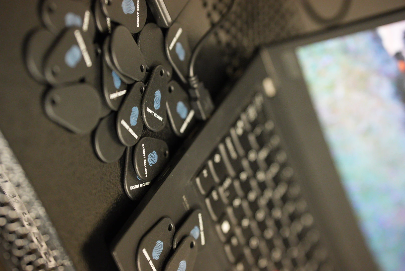 Tekniker justerar kontrollpanel medan hon håller en smartphone i moderna kontorslokaler.